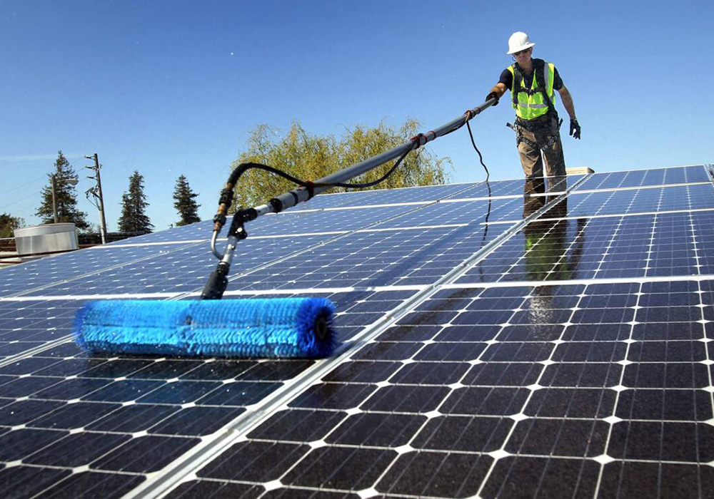 Sydney solar panel cleaning technician using specialized equipment on residential panels